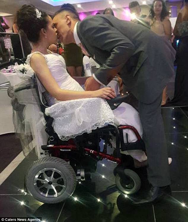 A devoted husband hoisted his paralysed bride into his arms so they could enjoy their first wedding dance 