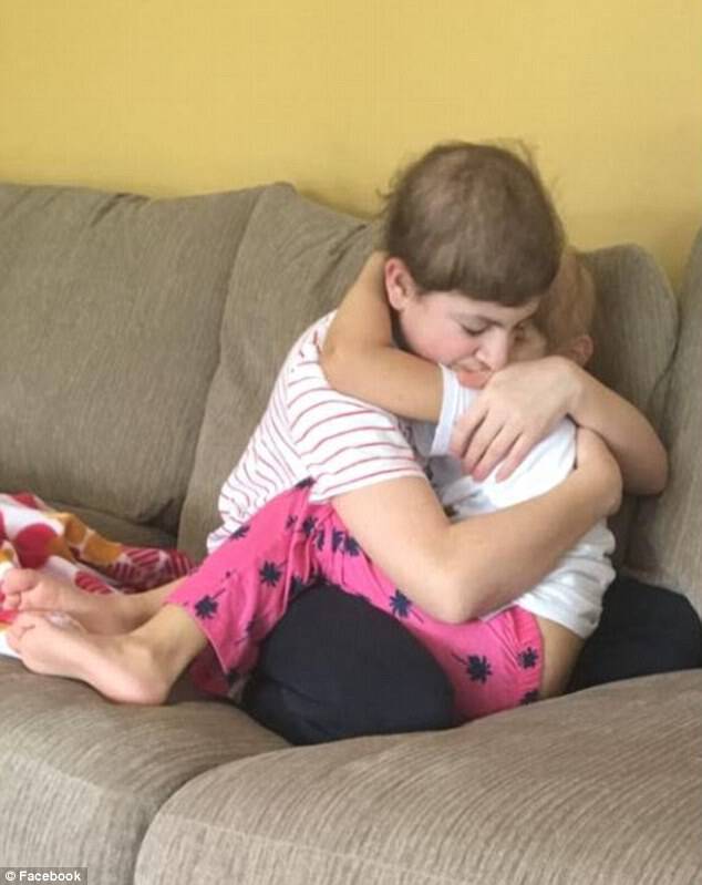 Jacob, 14, and his five-year-old sister hug as they both battle cancer. Their family had been told Jacob might not make it much longer when this photo was taken