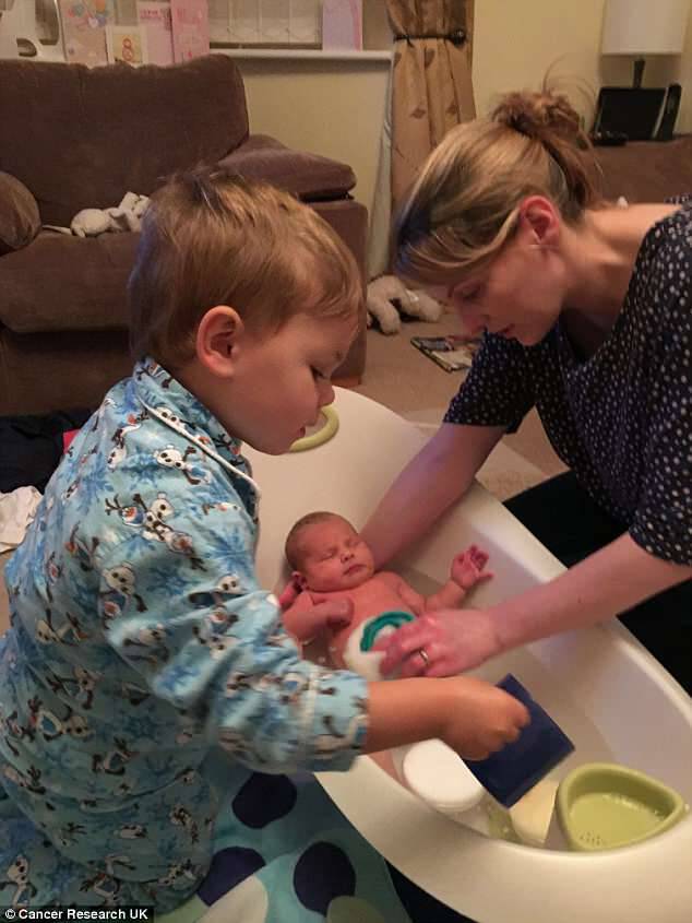 The mother-of-two - pictured with Michael bathing Esme as a newborn - is doing well after surgery last February and six months of chemotherapy because the cancer had spread to her lymph nodesÂ 