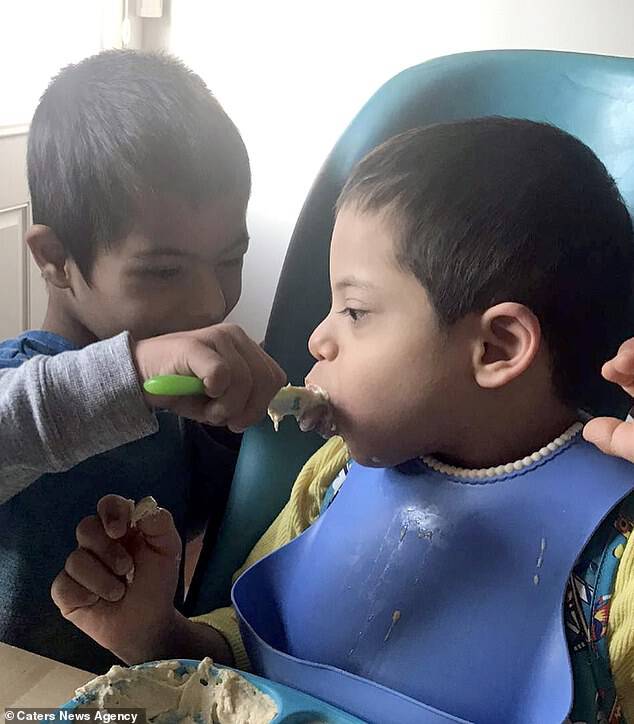 Since moving from Bulgaria last month, Simon helps his siblings eat using spoons and feeding syringes- seen feeding brother Alex,Â six, who also has Down's Syndrome