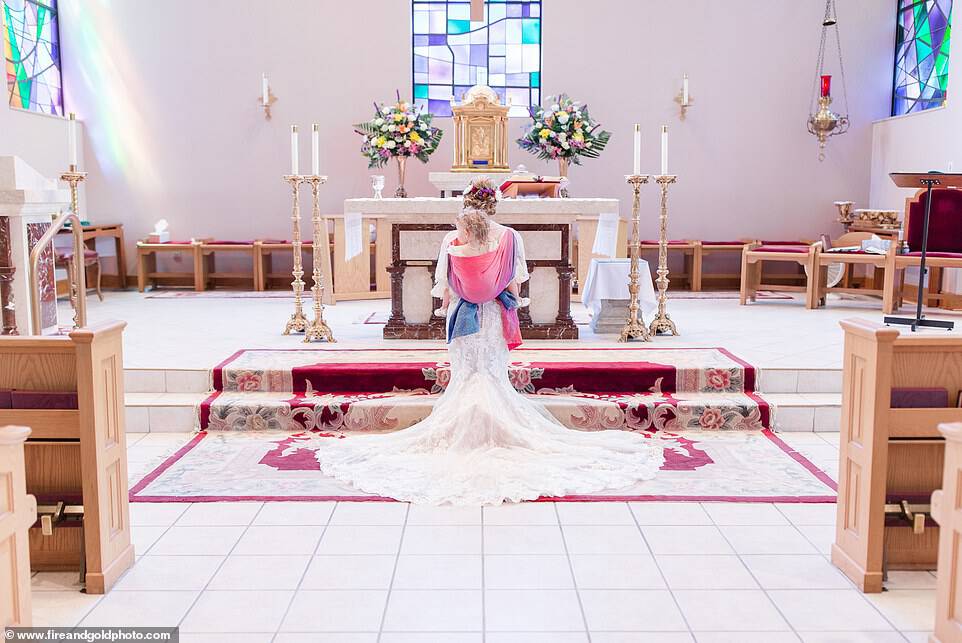 Gorgeous: Her decision to have the girl strapped to her back for the ceremony was also a practical one. The ceremony was aÂ  Roman Catholic mass, which can often last for anywhere between 40 minutes to over one hour